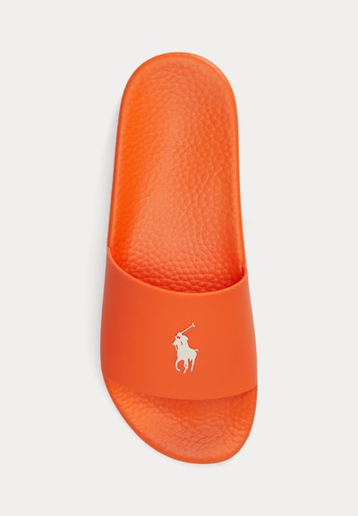 Svetlo oranžová šľapka s textúrovanou podrážkou a bielym logom hráča polo na širokom remienku cez vrch.