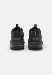 Black athletic shoes with textured mesh fabric, contrasting dark gray accents, and reflective detailing on the heel. Thick rubber outsole for traction.