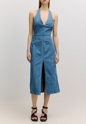 Jeans halterjurk met een diepe V-hals, knielang en met een split aan de voorkant. Kenmerkt zichtbare naaddetails en een aansluitende taille.