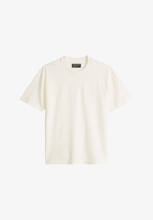 Prosty biały bawełniany t-shirt z krótkim rękawem i okrągłym dekoltem, ułożony na płasko, z widoczną metką marki wewnątrz kołnierzyka.