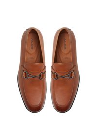 Ruskea nahkainen loafers-kengät, joissa on sileä pinta ja hopeanvärinen koristeketju edessä. Pyöreä kärki ja pehmustettu sisäpohja.