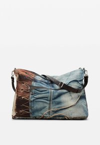 Schultertasche mit Jeansmuster und braunem Ledergriff, ausgestattet mit einem Seitenreißverschluss und Schnürdetails auf einer Seite. Strukturierte Stoffoberfläche.
