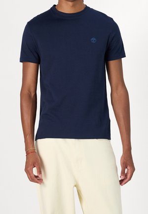 Granatowy bawełniany t-shirt z krótkim rękawem, okrągłym dekoltem i małym logo na lewej piersi. Miękka faktura, prosty design i klasyczny krój.