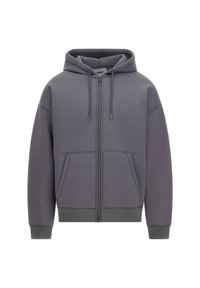 Sudadera con cremallera gris, con un bolsillo delantero, puños y dobladillo acanalados. Presenta un logo en un tono ligeramente más oscuro en el pecho. Textura de tela suave.