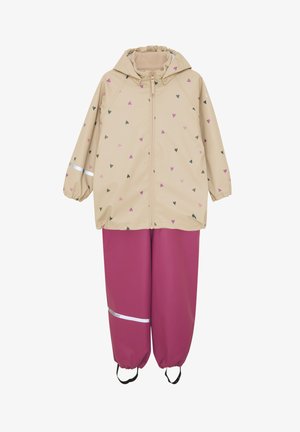 Veste de pluie beige avec motifs de cœurs roses et verts, fermeture éclair frontale, capuche, poignets élastiques, associée à un pantalon imperméable rose assorti, accents réfléchissants.