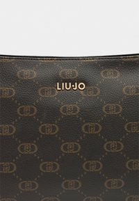 Bruine, gestructureerde leren tas met een geometrisch logo patroon en in goudtone geëmboste 'LIUJO' letters in het midden bovenaan.