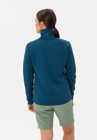 Top a maniche lunghe blu con motivo, colletto alto, abbinato a pantaloni shorts verde chiaro, caratterizzati da una vestibilità rilassata e superficie texturizzata.