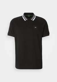 Polo noir à manches courtes avec col rayé blanc et petit logo "BOSS" sur la poitrine gauche.