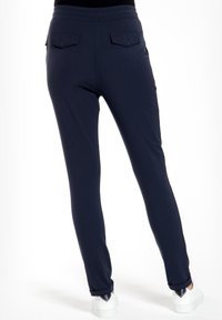 Marineblauwe stretchbroek met een gladde textuur, voorzien van twee achterzakken met knoopsluitingen en een flexibele tailleband. Perfecte pasvorm en enkel lengte.