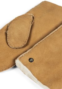 Hellbraune Wildlederhandschuhe mit einer abgerundeten Klappe, weicher Innenfutter und einem kleinen schwarzen Metalllogo-Dorn. Sichtbare Nähte entlang der Ränder.