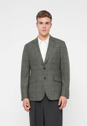 Grau karierter Blazer mit zwei Knöpfen, Reverskragen und Seitentaschen. Trägt man über einem weißen Hemd, das einen maßgeschneiderten Schnitt und eine glatte Textur aufweist.