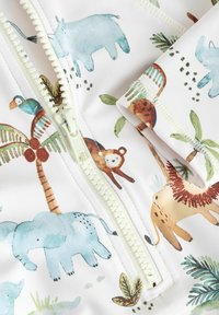 La tela de bañador con cremallera presenta un fondo claro con diseños coloridos de animales pintados a mano, incluyendo elefantes, aves y monos.