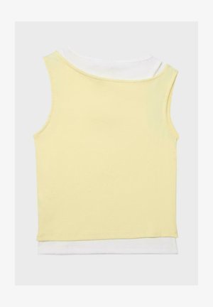 Żółty prążkowany, bezrękawnik typu crop top nałożony na biały top na jasnym, jednolitym tle.