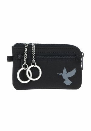 Pochette noire zippée avec deux porte-clés argentés suspendus à des chaînes et un dessin d'une colombe grise tenant un rameau d'olivier.