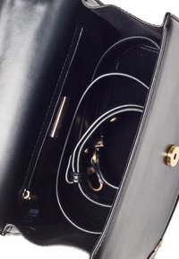 Wnętrze czarnej skórzanej torby z gładką strukturą, złotymi akcentami oraz wieloma przegrodami z zamkiem błyskawicznym i zaczepem do organizacji.