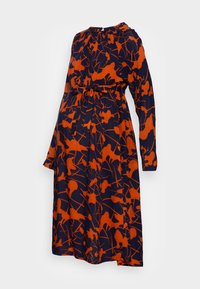 Långärmad gravidklänning i marinblått tyg med ett orange abstrakt blommönster, som har ett knytbälte och rundad halsringning.