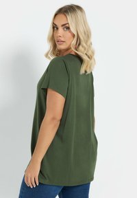 Olivengrøn t-shirt med korte ærmer og løs pasform, der har en rund halsudskæring og en glat, blød tekstur.