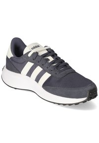 Granatowe buty sportowe z białymi paskami, oddychająca tekstylna cholewka i gumowa podeszwa. Cechuje je okrągły czubek i sznurowane zapięcie.