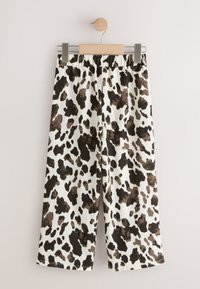 Weit geschnittene Hosen aus strukturiertem Stoff mit weißem Grundton und großem, schwarz-braunem Tierprint. Elastischer Bund am oberen Rand.