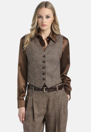 Brown houndstooth vest with a fitted design, button closure, worn over a shiny brown shirt, paired with high-waisted plaid trousers and a belt.