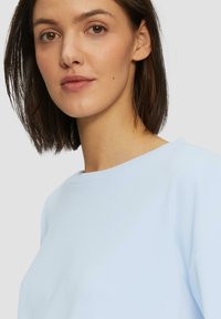 Lichtblauwe sweatshirt met een ronde hals en een zachte textuur, met een losse pasvorm en lange mouwen. Geen zichtbare patronen of hardwaren.