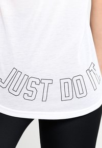 Witte T-shirt met de tekst "JUST DO IT." in zwart, met een ronde hals en korte mouwen, gemaakt van lichtgewicht stof.