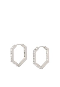 Orecchini a cerchio esagonali in argento con accenti di cristallo trasparente su un lato, caratterizzati da una finitura lucida e incisione del logo.