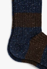 Calcetines de punto con rayas azules y marrones, texturizados con motas. Diseño acanalado en el puño y talón reforzado para mayor durabilidad.