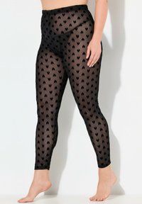 Leggings neri trasparenti con un motivo a piccoli cuori su tutta la superficie, design a vita alta, texture morbida e taglio alla caviglia.