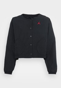 Svart kort jacka med långa ärmar, med knappstängning, elastiska ärmar, två framfickor och en röd Jordan-logotyp på bröstet.