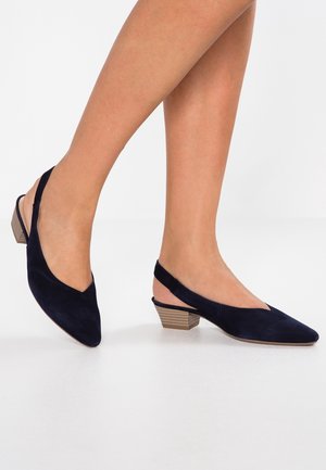 Granatowe zamszowe buty na obcasie typu slingback z zaostrzonym noskiem i niskim, teksturowanym blokowym obcasem. Z przodu znajduje się wycięcie w kształcie litery V.