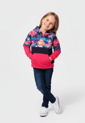Kolorowa bluza z kapturem z tropikalnym wzorem w odcieniach różu, niebieskiego i granatowego. W zestawie ciemne dżinsy i białe trampki.