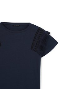 T-shirt blu navy con maniche corte, caratterizzato da un bordo in pizzo nero e dettagli con frange sulle spalle. Tessuto morbido e liscio, scollo rotondo.