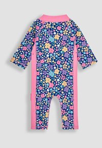 Bañador de manga larga en azul marino con un estampado floral en rosa, morado y amarillo, con paneles laterales rosas y un cuello alto.