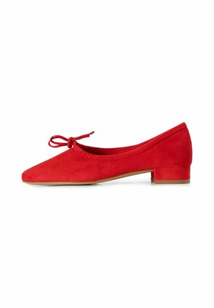 Rode suède ballerina met een kleine blokhak en een gestrikte strik op de afgeronde neus, zijaanzicht op een witte achtergrond.