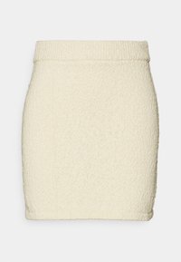Jupe mini en tricot de couleur crème avec une finition texturée, présentant une taille haute et un ourlet sans couture pour une silhouette épurée.