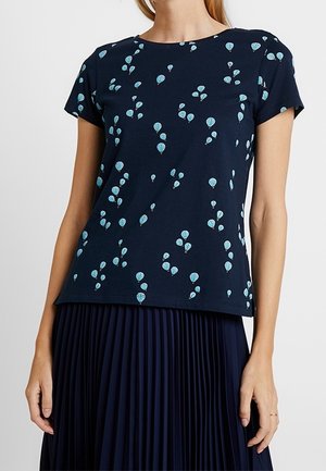 Marineblå kortærmet top med lyseblåt luftballonprint, kombineret med en marineblå plisseret nederdel.