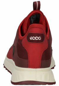 Scarpa sportiva rossa in materiale mesh e sintetico, con suola spessa bianca, colletto imbottito e dettagli del logo sul retro.