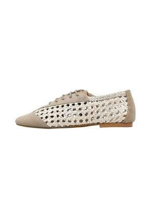 Zapato plano beige con cordones en la parte delantera y paneles laterales tejidos en plata metálica y beige, con puntera puntiaguda y tacón bajo.