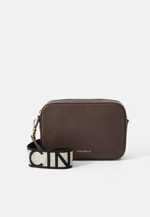 Brown leather crossbody bag with a textured finish, rectangular shape, gold hardware, and a black and cream logo strap.