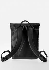 Zaino in pelle nera con spallacci imbottiti regolabili, maniglia superiore e chiusura con doppia cerniera. Design minimalista con texture liscia e senza motivi visibili.