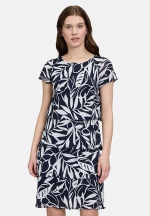 Abito a strati blu navy e bianco con stampa a foglie, maniche corte, scollatura rotonda e dettagli a volant all'orlo e ai bordi delle maniche.