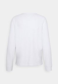 Weißes Langarmshirt aus texturiertem Stoff, mit gerippten Bündchen und einem V-förmigen Ausschnitt auf der Rückseite. Es hat eine lockere Passform und einen geraden Saum.