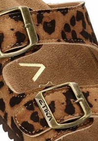 Sandalia de ante marrón con estampado de leopardo, dos correas ajustables con hebillas metálicas y una plantilla texturizada. Detalle del logo en dorado visible.