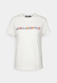 Bílý bavlněný tričko s potiskem "KARL LAGERFELD" v duhových, vzorovaných písmenech na přední straně. Krátké rukávy, kulatý výstřih.