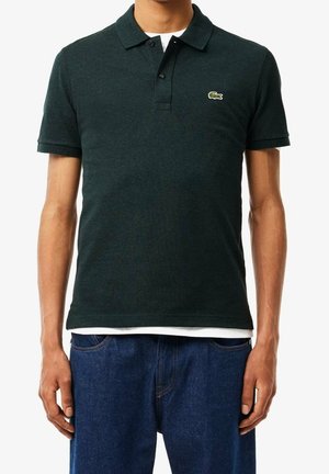 Polo de color verde oscuro con cuello, dos botones, mangas cortas y una tela texturizada. Presenta un pequeño logo bordado en el pecho.