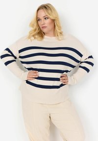 Maglione a maglia color crema con strisce orizzontali blu navy, dal taglio comodo e maniche lunghe. Texture liscia con scollatura rotonda.