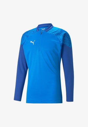 Langarm kwart-rits trui in het blauw met een textuurpatroon in geometrische vormen op de schouders, met een wit logo op de borst.