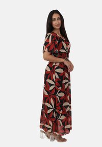 Maxikleid mit schwarzem Hintergrund und auffälligen roten und beigefarbenen Blumenmustern. Kurze Ärmel, taillierte Passform und fließender Rock. Transparente Absätze.