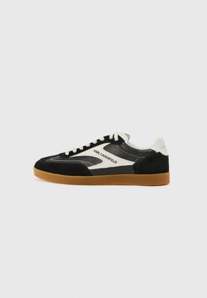 Black and white low-top sneakers with suede and leather materials, featuring a gum rubber sole and "Karl Lagerfeld" logo detail.